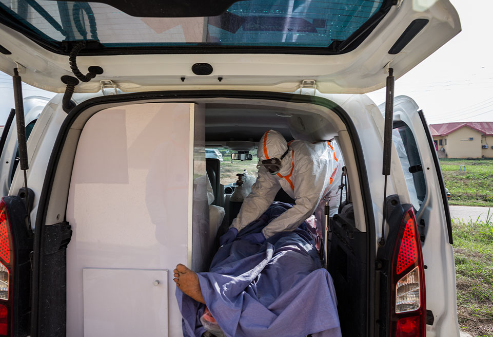 . Un hygiéniste essaie de couvrir un patient peu après qu'il ait été mis dans l'ambulance