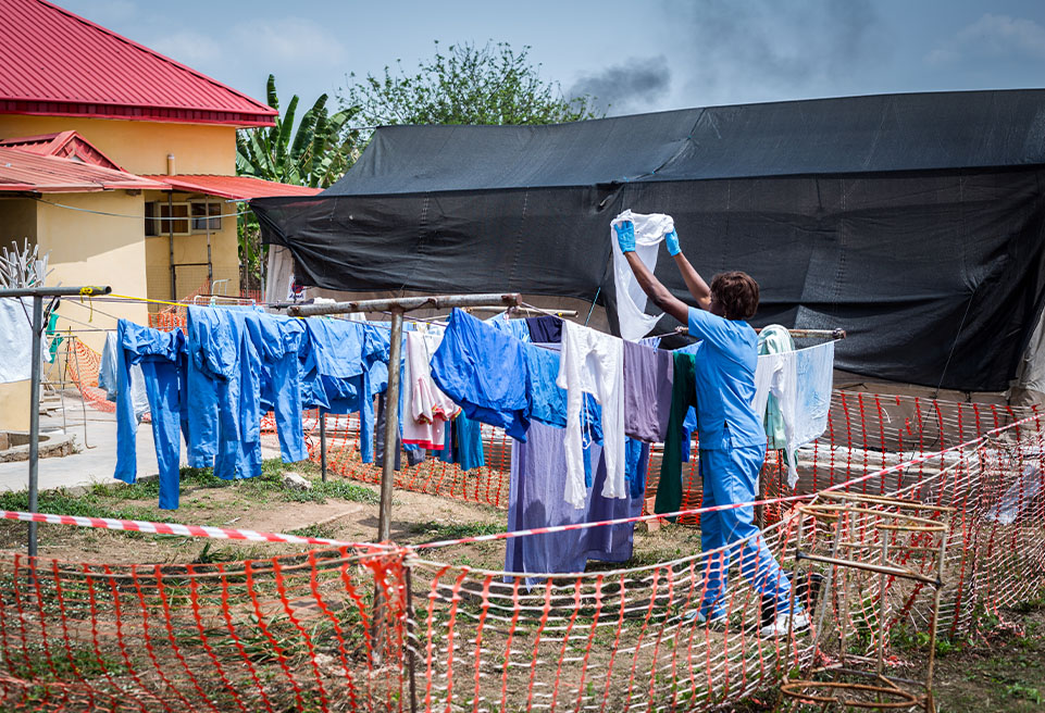 Un hygiéniste sèche certains vêtements réutilisables qui ont été soigneusement désinfectés, lavés et rincés